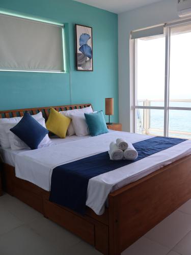 a bedroom with a large bed with towels on it at Beach Front 2 by A & A Villas in Uswetakeiyawa
