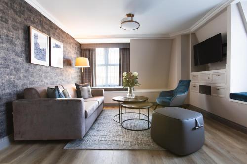 a living room with a couch and a table at The Rathbone Hotel, Fitzrovia in London