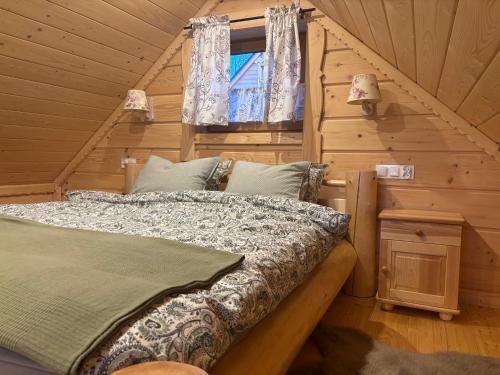 a bedroom with a bed in a log cabin at Osada na Skale Domek z kominkiem in Istebna
