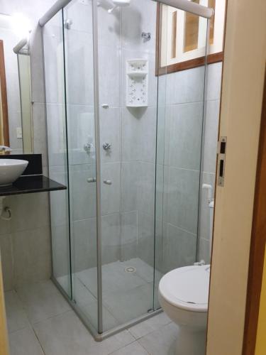 a glass shower with a toilet and a sink at Hotel blue Ocean 3 in Parnamirim