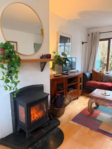 a living room with a fireplace and a mirror at Large cosy home with garden, excellent location! in Galway