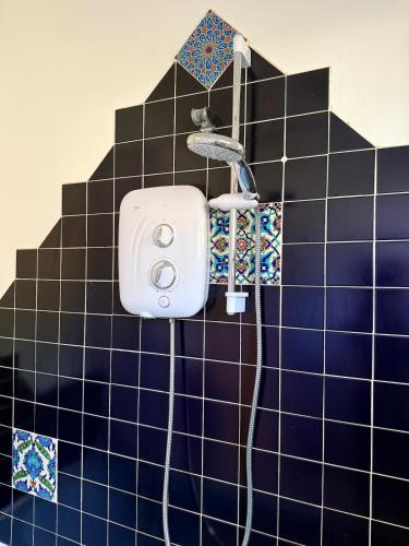 a blue tiled bathroom with a hair dryer on a wall at Large cosy home with garden, excellent location! in Galway