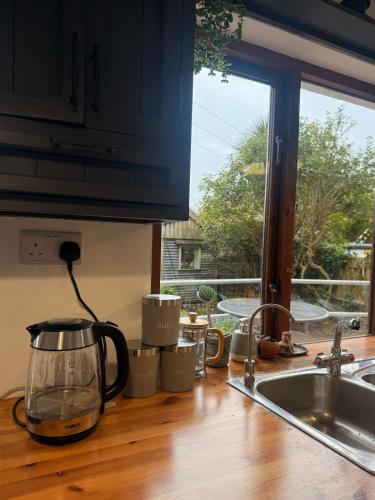 a kitchen counter with a tea kettle and a window at Large cosy home with garden, excellent location! in Galway
