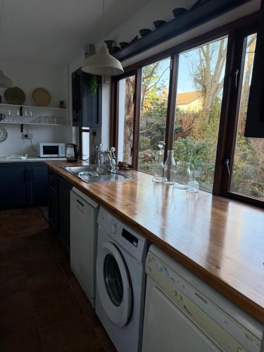 a kitchen with a wooden counter top with a washing machine at Large cosy home with garden, excellent location! in Galway