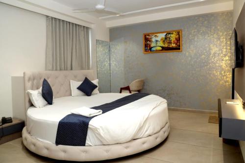 ein Schlafzimmer mit einem großen weißen Bett in einem Zimmer in der Unterkunft hotel the perfect in Ahmedabad