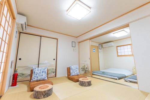 a room with two chairs and a bed at Guest House Kubo Homes Tanimachi in Osaka