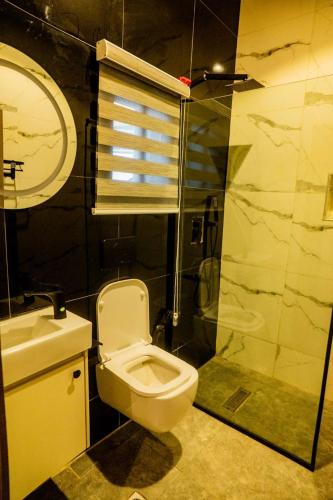 a bathroom with a toilet and a sink and a shower at EXQUISITE Home 2 Abuja in Abuja