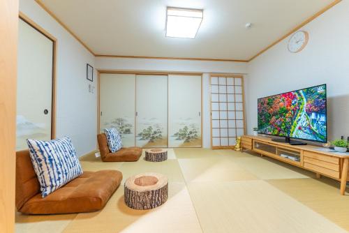 a living room with a large flat screen tv at Guest House Kubo Homes Tanimachi in Osaka