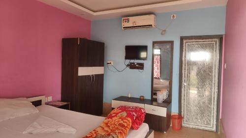 a bedroom with a bed and a room with a fan at Hotel Mainak Mandarmoni in Mandarmoni
