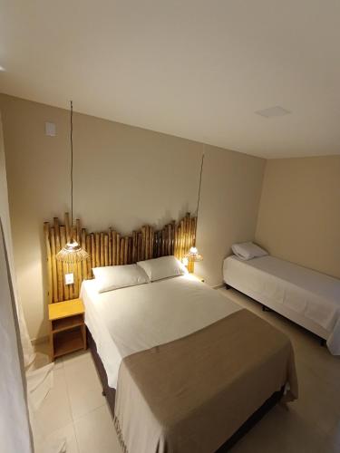 a hotel room with two beds and two lamps at Recanto dos Coraiss in Marau