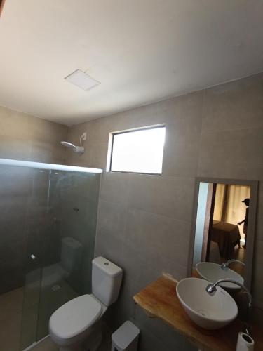 a bathroom with a toilet and a sink and a shower at Recanto dos Coraiss in Marau