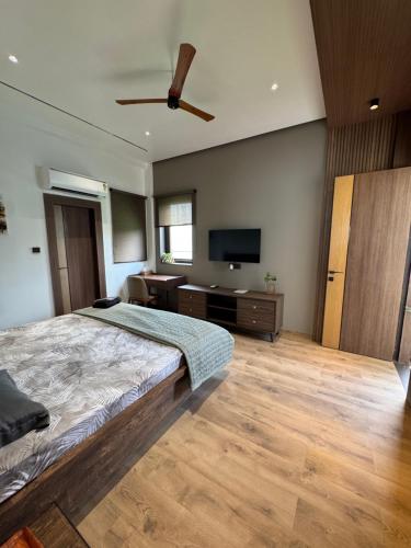 a bedroom with a bed and a flat screen tv at Skywood Villa Rooms in Lucknow