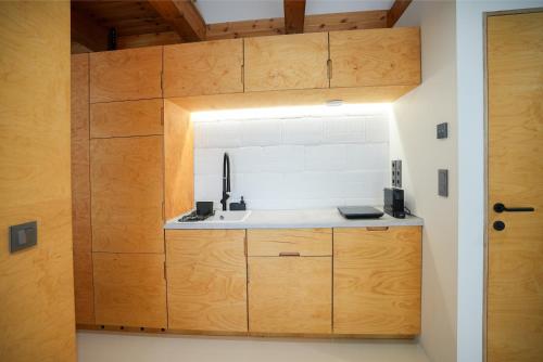 a small kitchen with a sink and wooden cabinets at GG3 guesthouse in Eger
