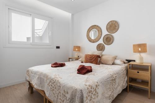 a white bedroom with a large bed with a window at Fuengirola I in Fuengirola