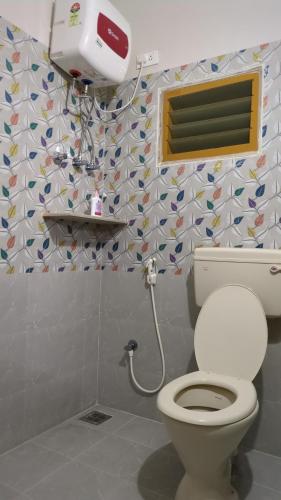 a bathroom with a toilet and a window at RKVilla in Tirupati