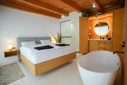 a bedroom with a large bed and a bath tub at GG3 guesthouse in Eger