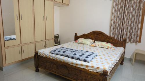 a bedroom with a wooden bed and a dresser at RKVilla in Tirupati