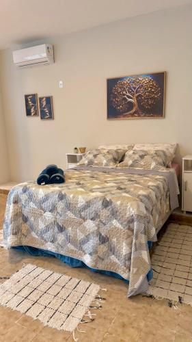 a bedroom with a bed with a blanket on it at Studio de Hóspedes - 150m da Praia in Rio de Janeiro