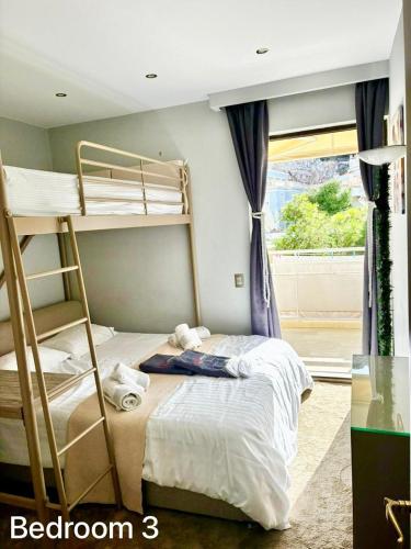 a bedroom with two bunk beds and a window at Villasonboard 3 Bed Penthouse Veranda Beach view jacuzzi Vouliagmeni Riviera in Athens