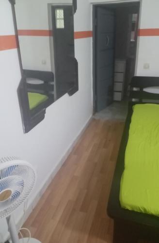una stanza con un letto, un tavolo e uno specchio di Chris a Abidjan