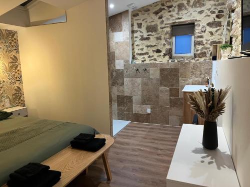 a room with a bed and a stone wall at La Merletière in Cholet