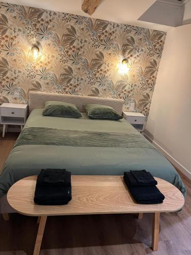 a bedroom with a bed with two black bags on it at La Merletière in Cholet