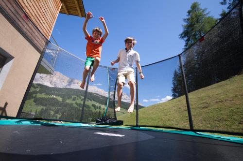 two people jumping in the air on a trampoline at Antorè in Badia