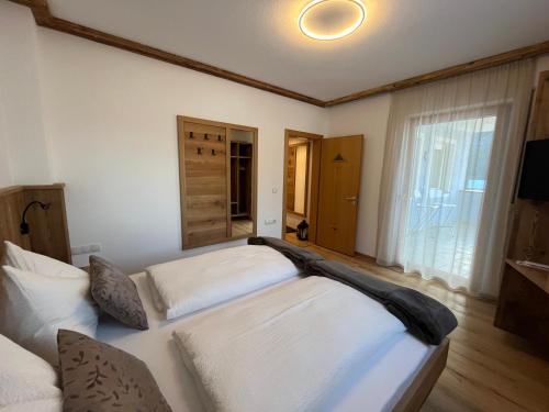 a bedroom with two beds and a large window at Mountain River Apartment in Chienes