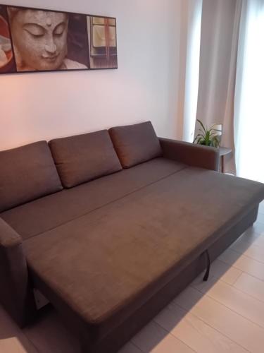a brown couch sitting in a living room at studio meublé wifi à proximité du tram in Castelnau-le-Lez