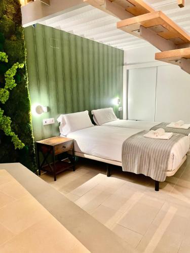 a bedroom with a bed and a green wall at Loft Manuel Arellano in Seville