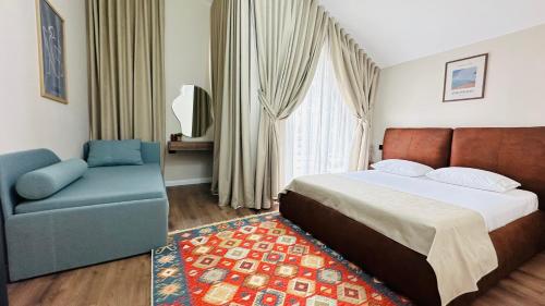 a bedroom with a bed and a couch and a chair at Villa Garden Boutique Hotel Tirana in Tirana