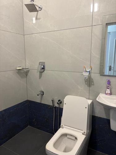 a bathroom with a toilet and a sink at Evania Pool Suites in Nedumbassery