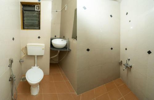 a bathroom with a toilet and a sink at Hotel Indira Nature Valley Mahabaleshwar in Mahabaleshwar