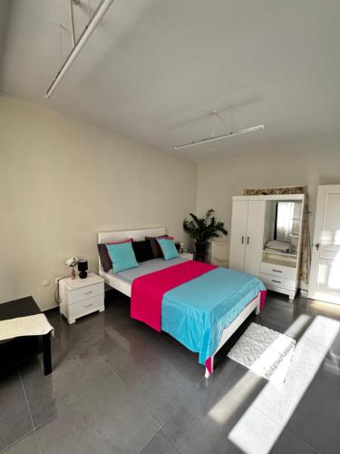 a bedroom with a large bed with blue and pink at Cozy Home with Terrace Views! in Ponta do Sol