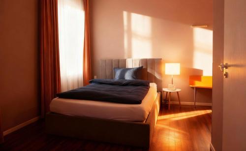 a bedroom with a bed with a blue pillow on it at Hotel Ambiente in Dortmund