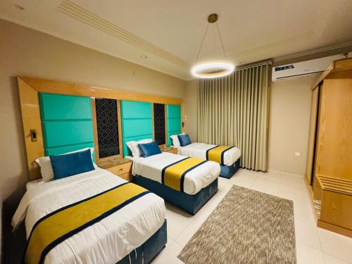 a hotel room with two beds and a rug at Rove Appartments in Taif