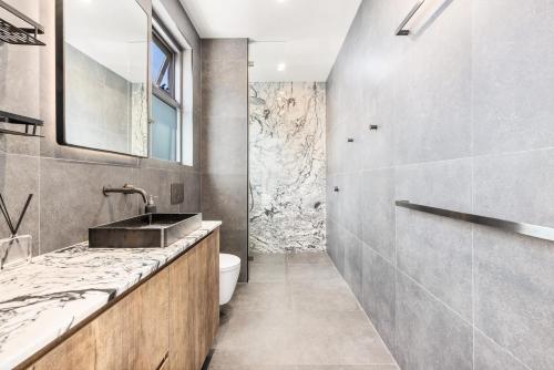 a bathroom with a sink and a toilet at Group & Family 3BR with Game Room, Terrace & Parking in Sydney