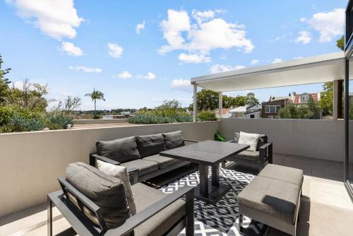 a patio with a table and chairs on a balcony at Group & Family 3BR with Game Room, Terrace & Parking in Sydney