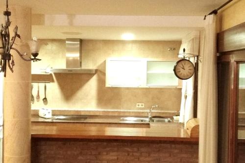 a kitchen with a sink and a clock on the wall at CASA RURAL ALTA YUBERIA in Berlanga de Duero