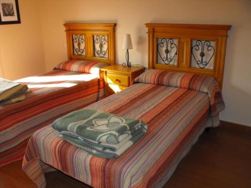 a bedroom with two beds and a lamp on a table at CASA RURAL ALTA YUBERIA in Berlanga de Duero