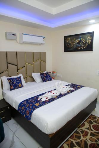a bedroom with a large bed with blue lights at The Manor Inn in Phagwāra