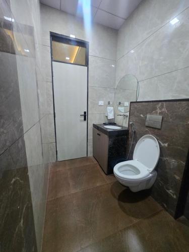 a bathroom with a white toilet and a sink at Hotel Shree Karni Palace in Kishangarh
