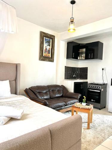 a living room with a couch and a table at Rustic studio milimani in Kisumu