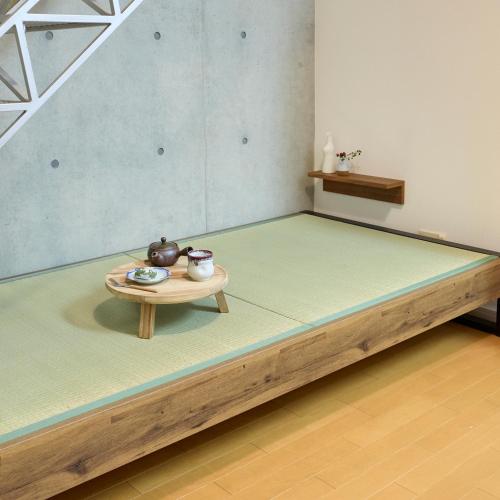 a bed with a table in a room at Grand Reve KODEKI Near Nagoya Dome in Yadachō