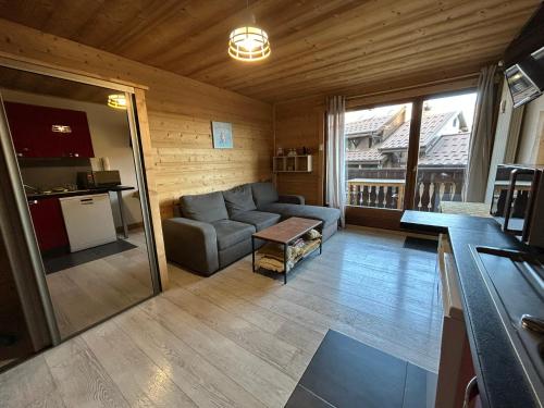 un salon avec un canapé et une cuisine dans l'établissement Studio équipé / centre station, aux Carroz d'Arâches