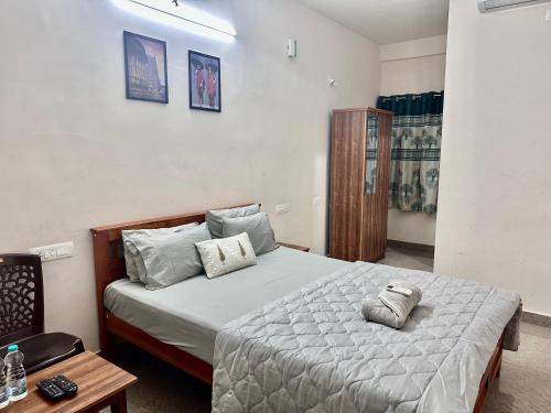 a bedroom with a bed with two pillows on it at Dhruvanish Grand in Sringeri
