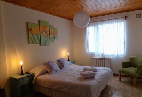 a bedroom with a bed and a chair and a window at avellaneda suites in Río Gallegos