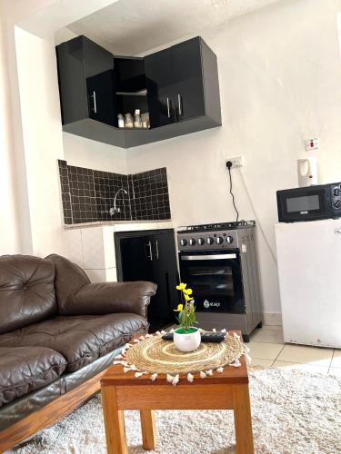 a living room with a couch and a table at Rustic studio milimani in Kisumu