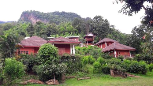 a row of red houses on a hill with trees at Saen Kam Resort in Chiang Mai