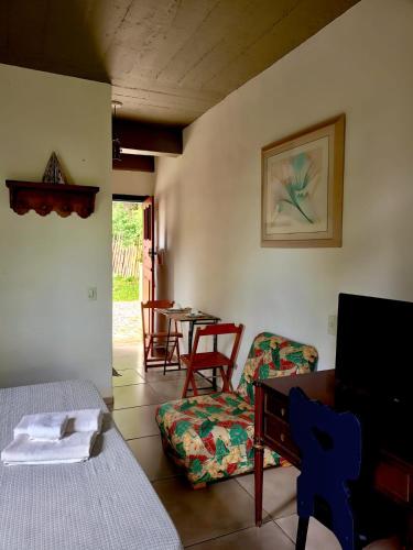 a room with a bed and a table and chairs at Charmoso studio em Tiradentes in Tiradentes